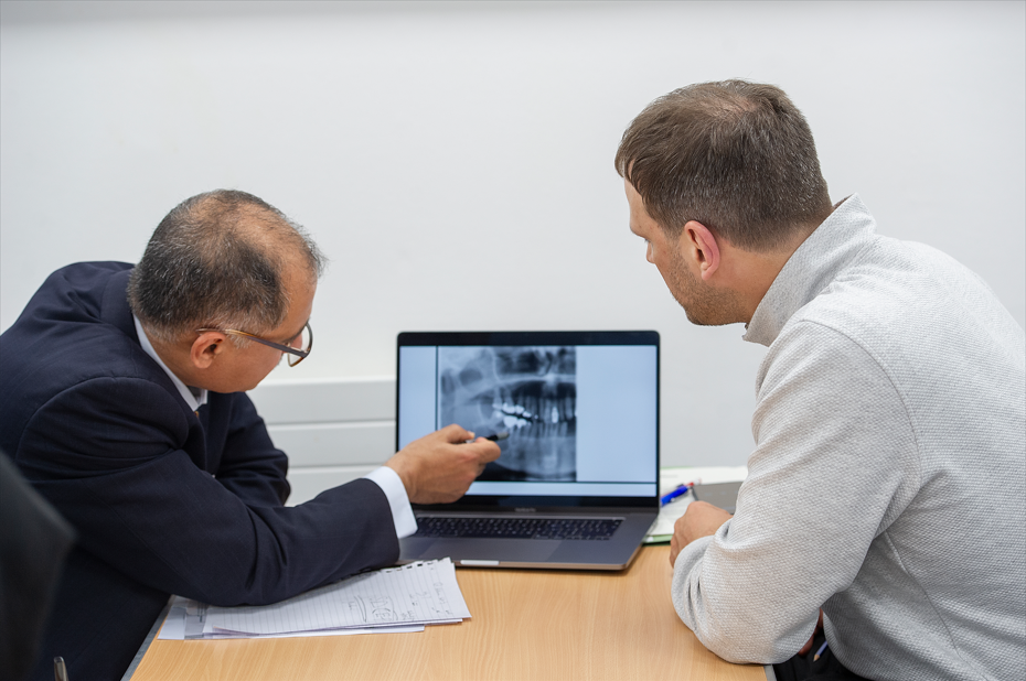 Examiner and candidate viewing x-ray on a screen